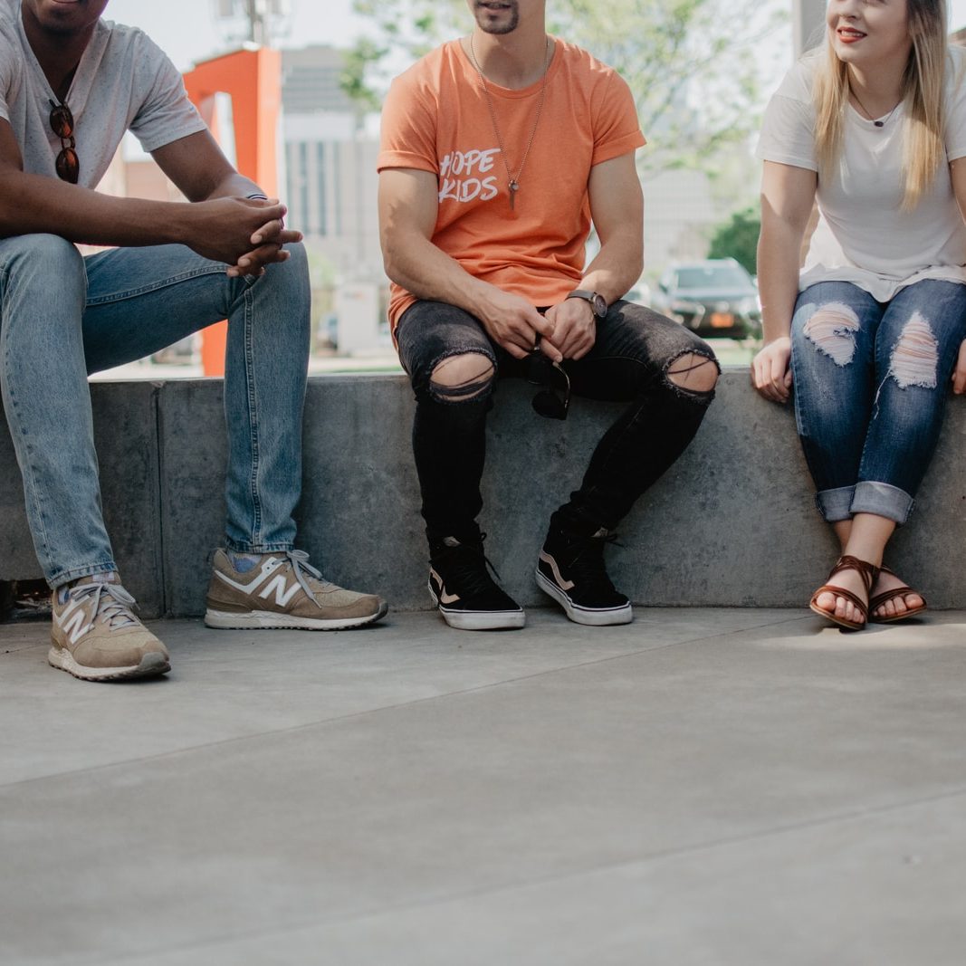 four persons sitting on concrete bench