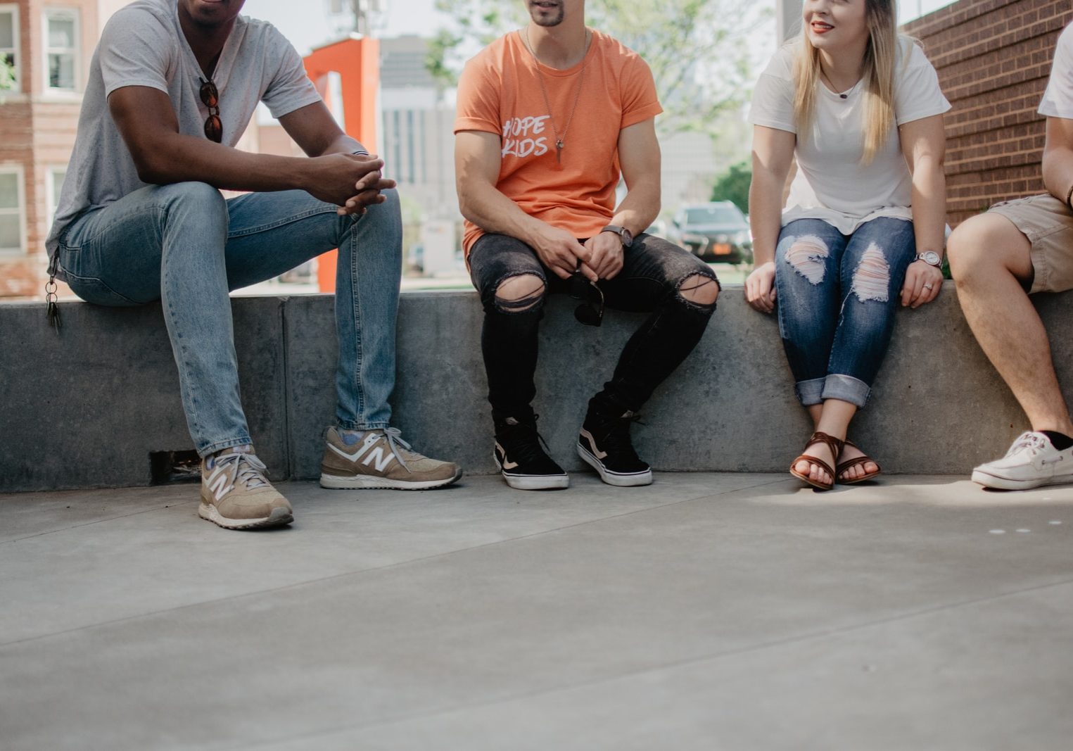 four persons sitting on concrete bench